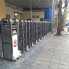 Hình ảnh thực tế mẫu cổng xếp hợp kim nhôm tự động thương hiệu Vingate màu xám đen, trang bị hệ thống bánh xe trượt được lắp đặt ngoài trời.